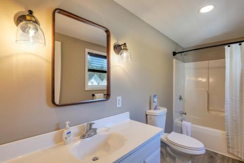 Un baño con lavabo, inodoro y espejo. en 2BR Condo Downtown SWH w/ Ocean Views [Driftwood], en Southwest Harbor