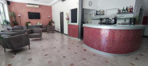 un bar dans un salon avec des chaises et un comptoir dans l'établissement Hotel Ardesia, à Rimini