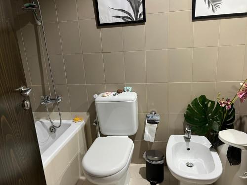 uma casa de banho com um WC, uma banheira e um lavatório. em Entire apartment in Remraam community em Dubai