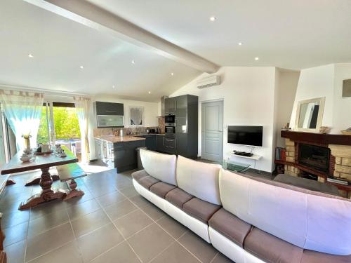 un grand salon avec un canapé et une table dans l'établissement Villa L'Ondella PORTICCIO, à Porticcio