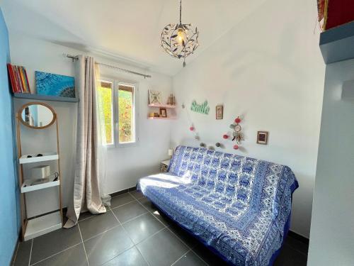 une chambre avec un lit bleu et une fenêtre dans l'établissement Villa L'Ondella PORTICCIO, à Porticcio
