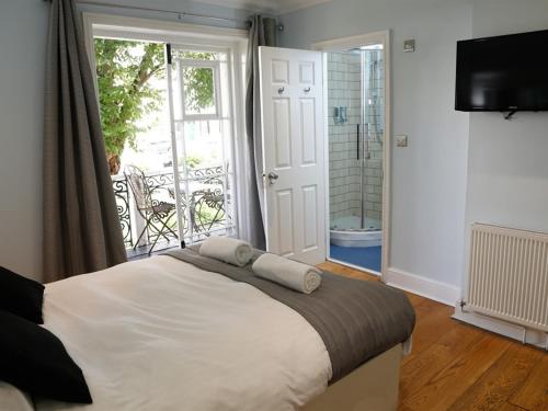 a bedroom with a bed and a balcony at Churchill Brighton in Brighton & Hove