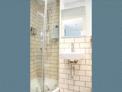 a bathroom with a shower and a sink and a mirror at Churchill Brighton in Brighton & Hove