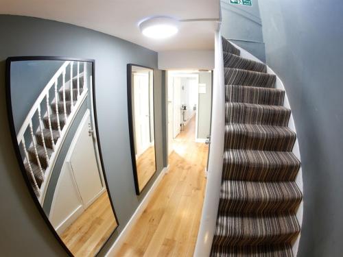 een trap in een huis met een spiegel bij INNit Joy in Brighton & Hove