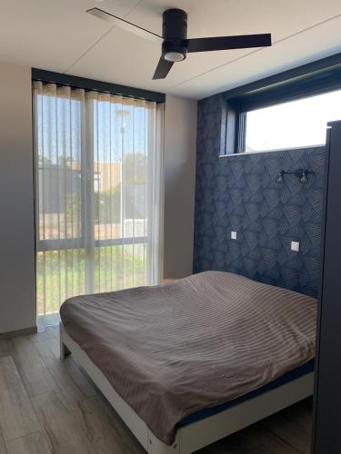 - une chambre avec un lit et un ventilateur de plafond dans l'établissement Weidezicht, à Cromvoirt