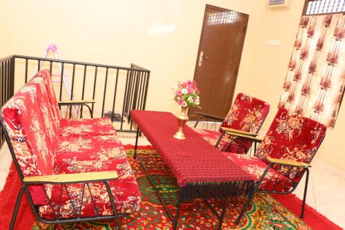 two chairs and a red bench on a balcony at Archu Agam in Kotagala