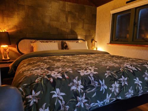 a bedroom with a large bed with a floral bedspread at B&B 't Maartensdijkse Bos in Maartensdijk