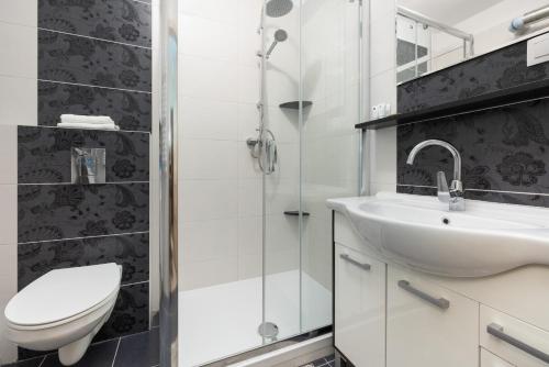 a bathroom with a sink and a toilet and a shower at Peaceful Apartment Wrzosowo Bay with Parking by Renters in Dziwnówek