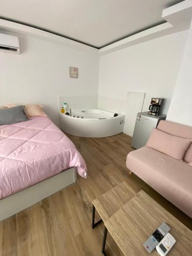 um quarto com uma cama rosa e uma mesa em PLAYA POSTIGUET em Alicante