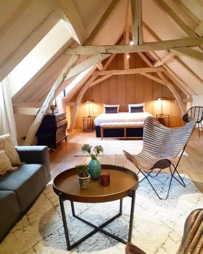 Cette chambre comprend un lit, un canapé et une table. dans l'établissement Domaine de la Limetiere, à Neuvy-le-Roi
