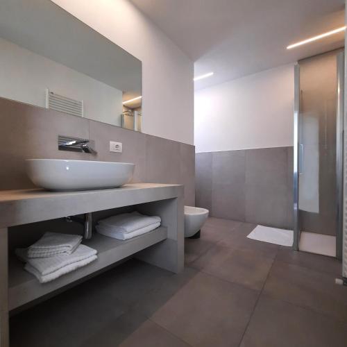 a bathroom with a sink and a toilet and a mirror at Residence Conca Verde 2 with pool in Trarego Viggiona