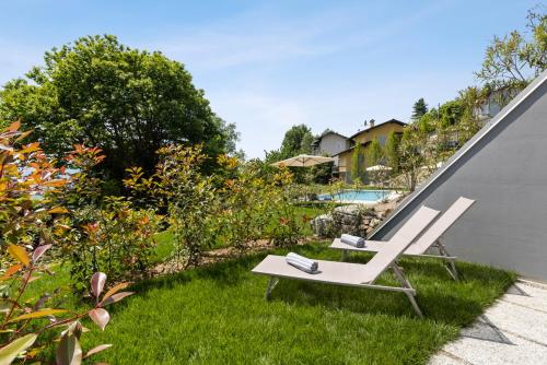 a couple of lounge chairs sitting on the grass in a yard at Residence Conca Verde 2 with pool in Trarego Viggiona