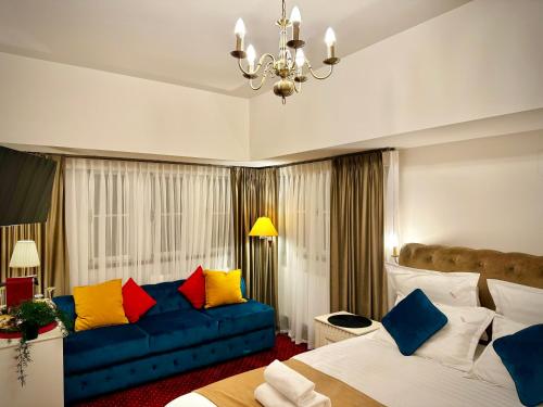 um quarto de hotel com duas camas e um sofá azul em Vila Șipot - Casa Arhitecților em Sinaia