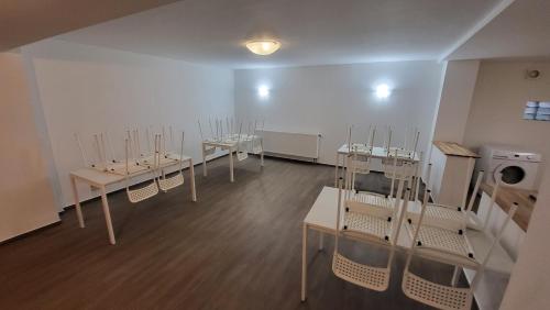 uma sala com mesas brancas e cadeiras em Zur Mühle em Lehnin