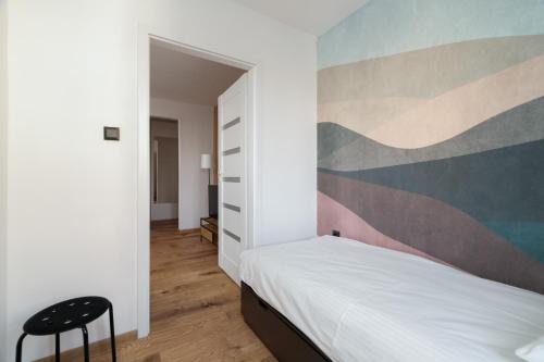 1 dormitorio con 1 cama y una pintura en la pared en Comfortable Two-Bedroom Apartment Poznań by Renters, en Poznan