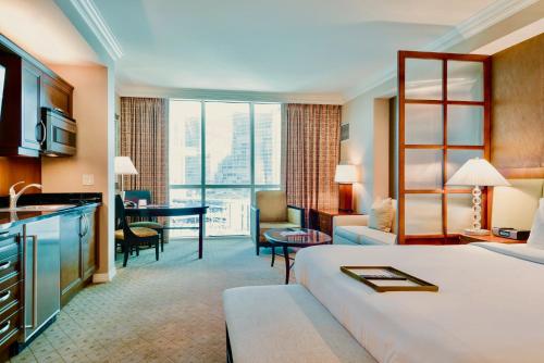 a hotel room with a large bed and a desk at Strip View Suites - No Resort Fee ! in Las Vegas