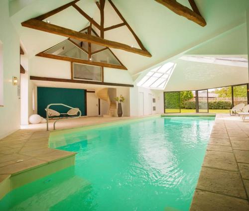 una gran piscina de agua azul en una casa en Domaine de la Limetiere, en Neuvy-le-Roi