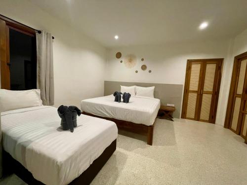 una habitación de hotel con 2 camas en una habitación en Sunny Cove Beach Resort Koh Phayam en Ranong