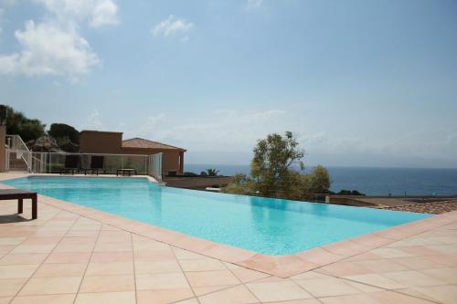 une grande piscine avec vue sur l'océan dans l'établissement Mini villa Hameaux des Sanguinaires AJACCIO, à Ajaccio