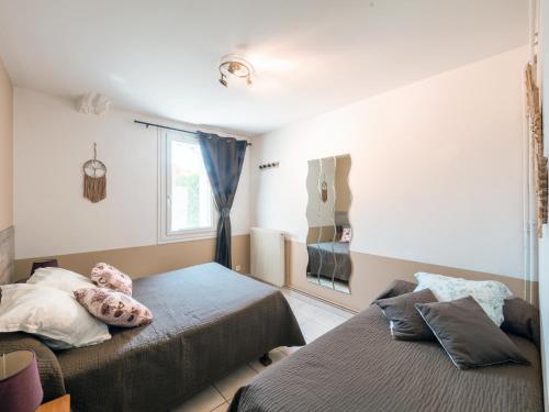 - une chambre avec 2 lits avec un animal rembourré sur l'oreiller dans l'établissement Appartement Soleil levant 4 à 5 Personnes, à Millau