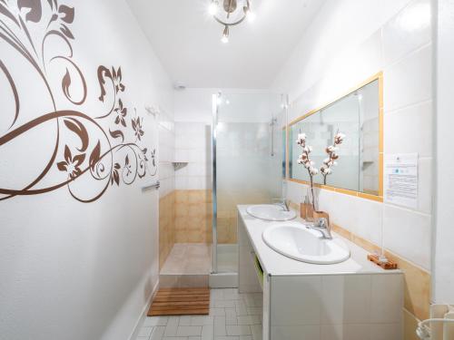 une salle de bain blanche avec deux lavabos et une douche dans l'établissement Appartement Soleil levant 4 à 5 Personnes, à Millau