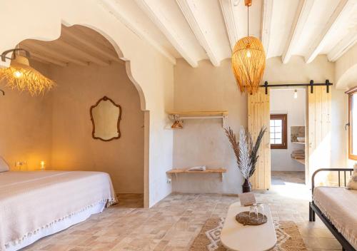 a bedroom with a bed and a couch and a table at Masia Aubareda in San Martín de Tous