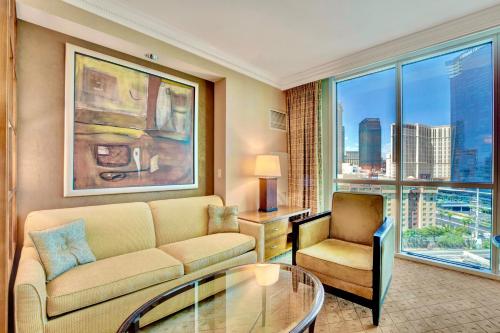 a living room with a couch and a glass table at Strip View Suites - No Resort Fee ! in Las Vegas