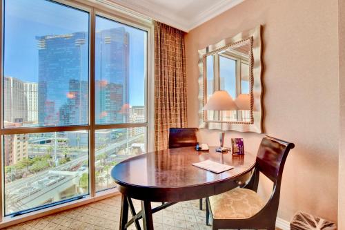 a table and chairs in a room with a large window at Strip View Suites - No Resort Fee ! in Las Vegas