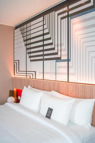a bedroom with a white bed with a large window at Pullman Lima Miraflores in Lima