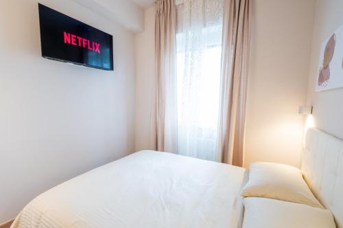 a small bedroom with a bed and a window at Palmanova Suites in Milan