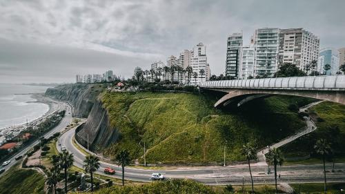 a bridge over a mountain with a city and the ocean at Pullman Lima Miraflores in Lima