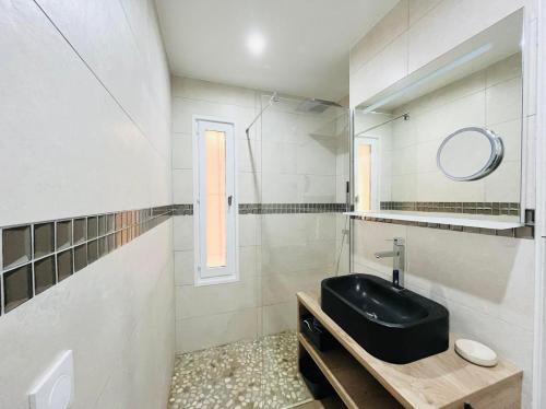 une salle de bain avec un lavabo noir et un miroir dans l'établissement Appartement Aria Marina 1 Lumio, à Lumio
