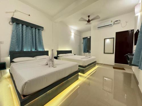 a bedroom with two beds and a ceiling fan at La Antilia Luxury - TIE Hotels in Pondicherry