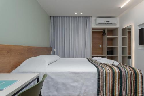 a bedroom with a white bed and a desk at Vistamar Hotel in Maceió
