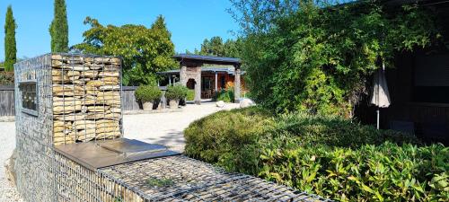 a stone wall with a fireplace in a yard at Les Chalets de Maramour in Chazey-sur-Ain
