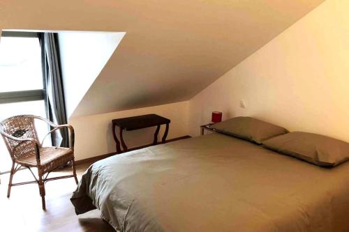 une chambre avec un lit, une chaise et une fenêtre dans l'établissement le relais st nicol, avec terrasse de 50m2 et parking privé, à Honfleur