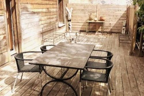 une table et des chaises en bois sur une terrasse dans l'établissement le relais st nicol, avec terrasse de 50m2 et parking privé, à Honfleur