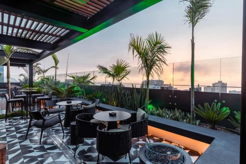 a restaurant with tables and chairs on a roof at Pullman Lima Miraflores in Lima