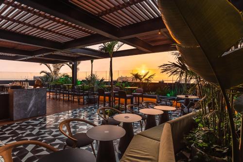 a restaurant with tables and chairs and the ocean at Pullman Lima Miraflores in Lima
