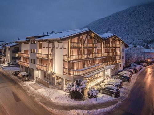 a large building with cars parked in front of it at Alpenhotel Tirolerhof in Fulpmes