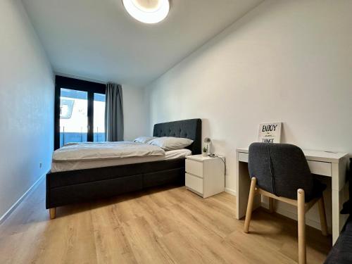 a bedroom with a bed and a desk and a chair at Vivien Modern City in Brno