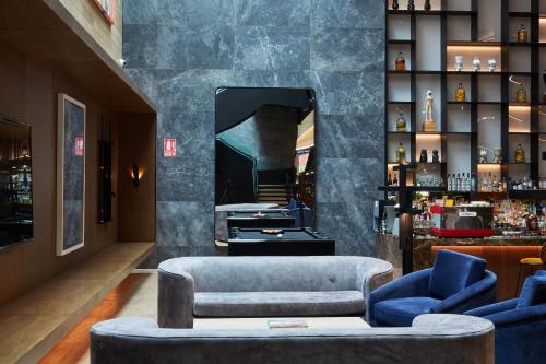 a lobby with blue chairs and a mirror at Pullman Lima Miraflores in Lima