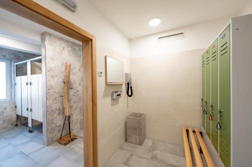 ein Badezimmer mit grünen Türen und einer ebenerdigen Dusche in der Unterkunft Spreewaldhotel Stephanshof in Lübben