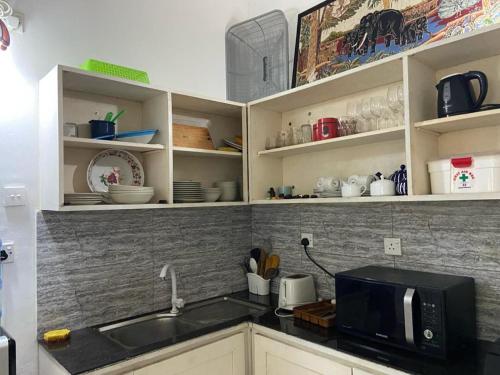 une cuisine avec un évier et un micro-ondes dans l'établissement Lady Nelly villa Hikkaduwa, à Hikkaduwa