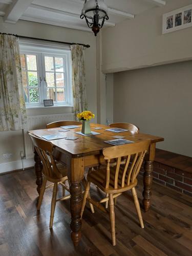 a dining room table with chairs and a vase of flowers on it at 5 Union Road in Lincoln