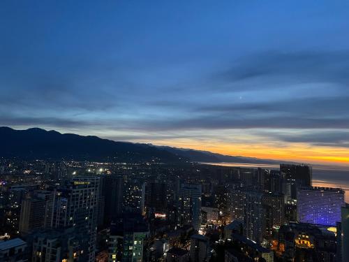 uma vista da cidade à noite em Elite Class Sea View ApartHotel in Orbi city em Batumi