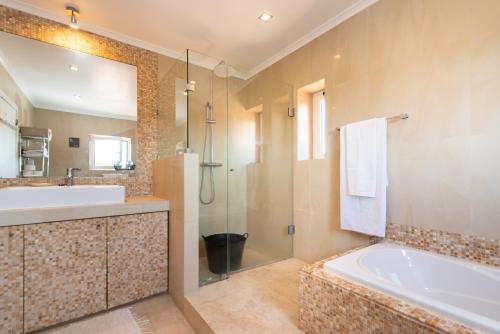 a bathroom with a tub and a sink and a mirror at Marigold Cascais Villa in Cascais