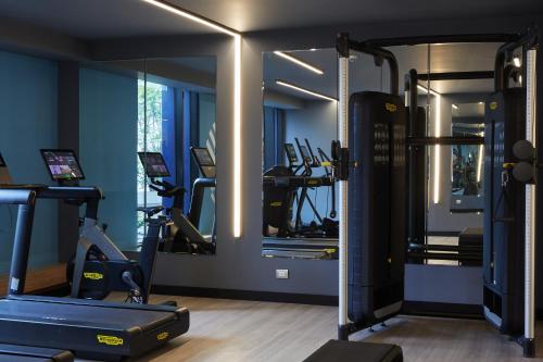 a gym with several tread machines and a mirror at Pullman Lima Miraflores in Lima