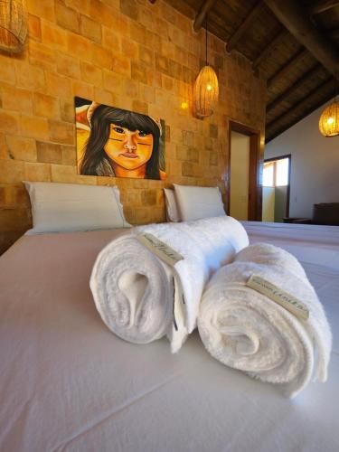 a bedroom with a bed with towels on it at Tawa Caraíva in Caraíva