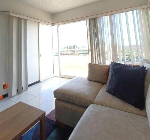 a living room with a couch and a large window at Laguna Suite & More in Porlamar
